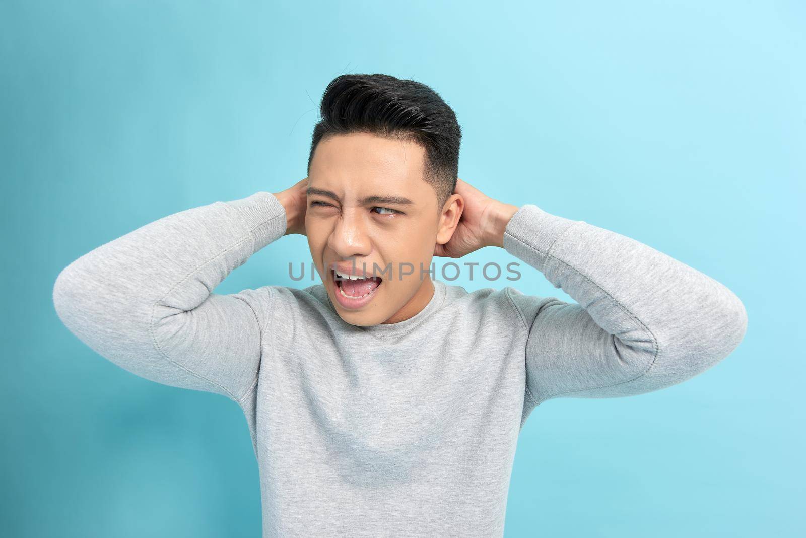 Emotion concept, Young asian man angry expression isolate on blue background,