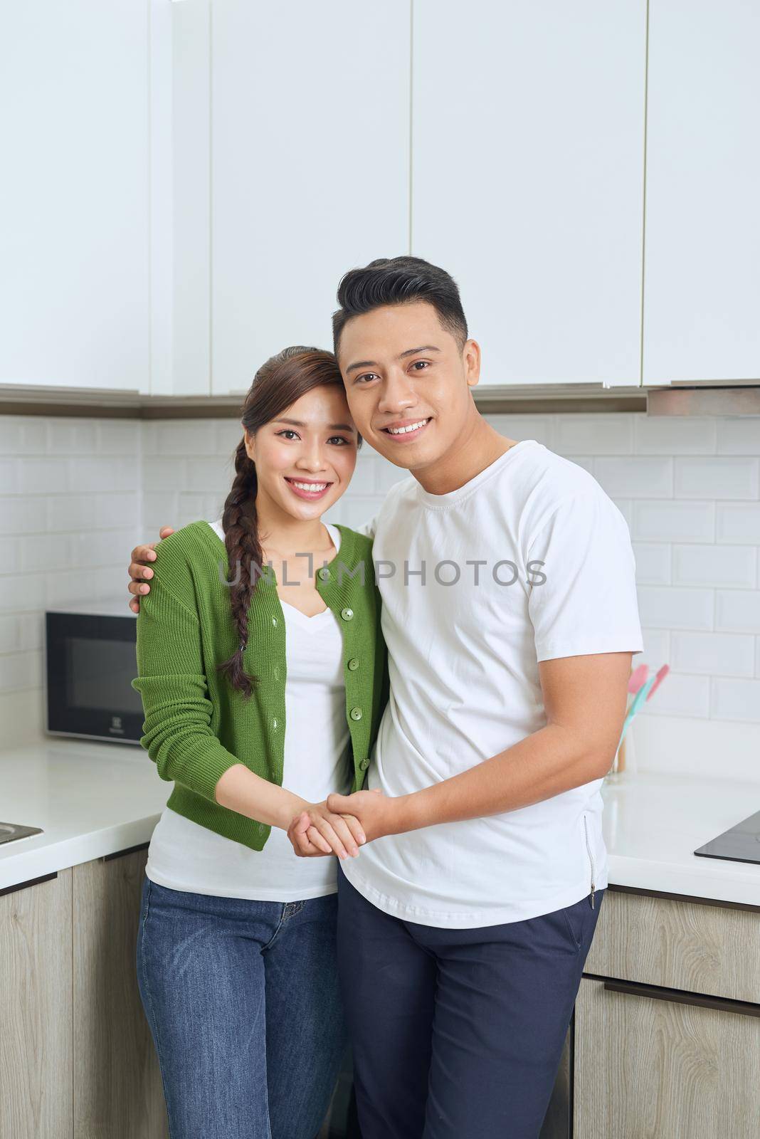 Romantic young couple cooking together in the kitchen,having a great time together. by makidotvn