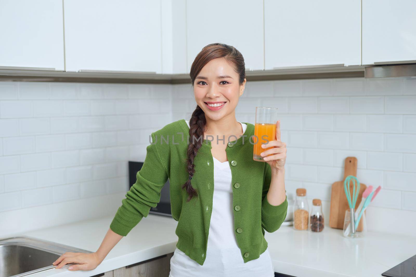 Young healthy asian woman drinking orange juice by makidotvn