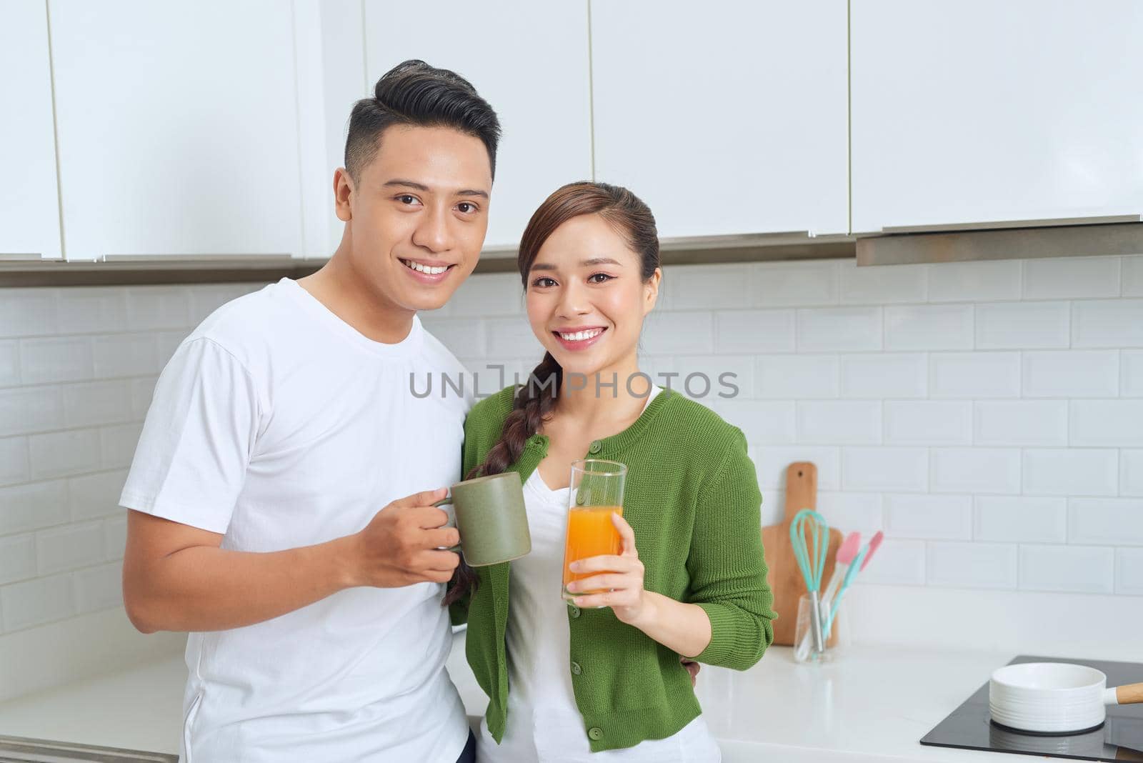 Lovely girl standing on the floor and talking with boyfriend. Young couple enjoying coffee in kitchen.