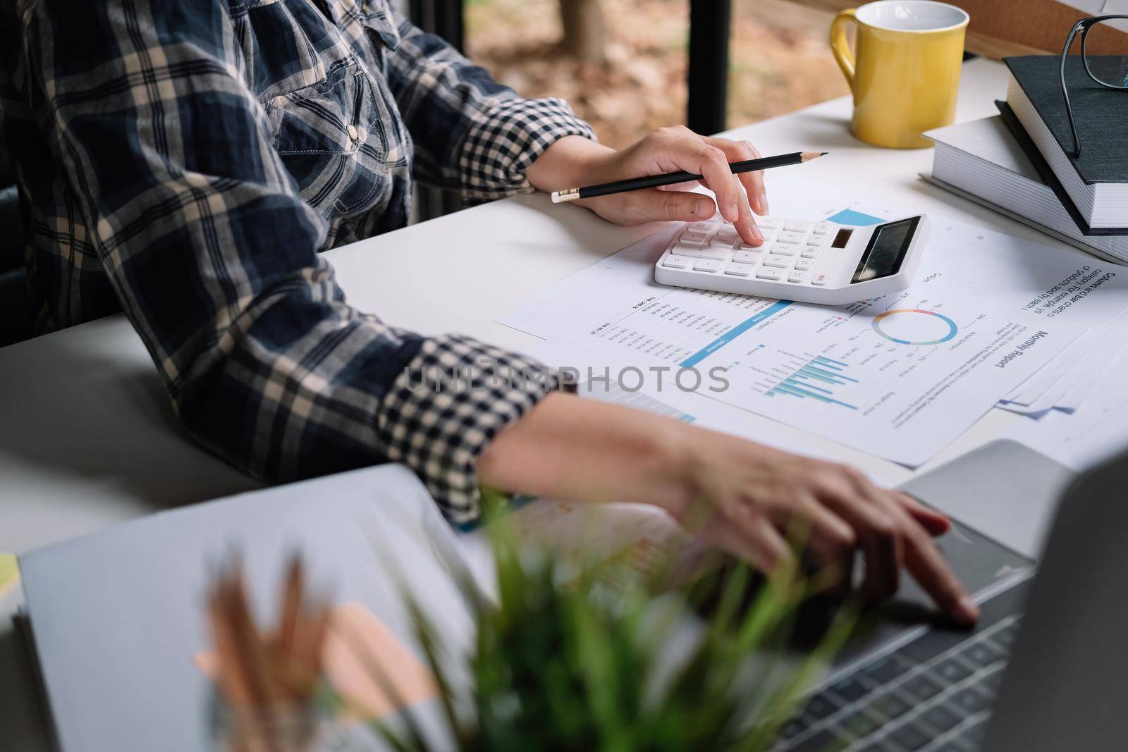 Close up woman working about financial with calculator at home office to calculate expenses, Accounting concept