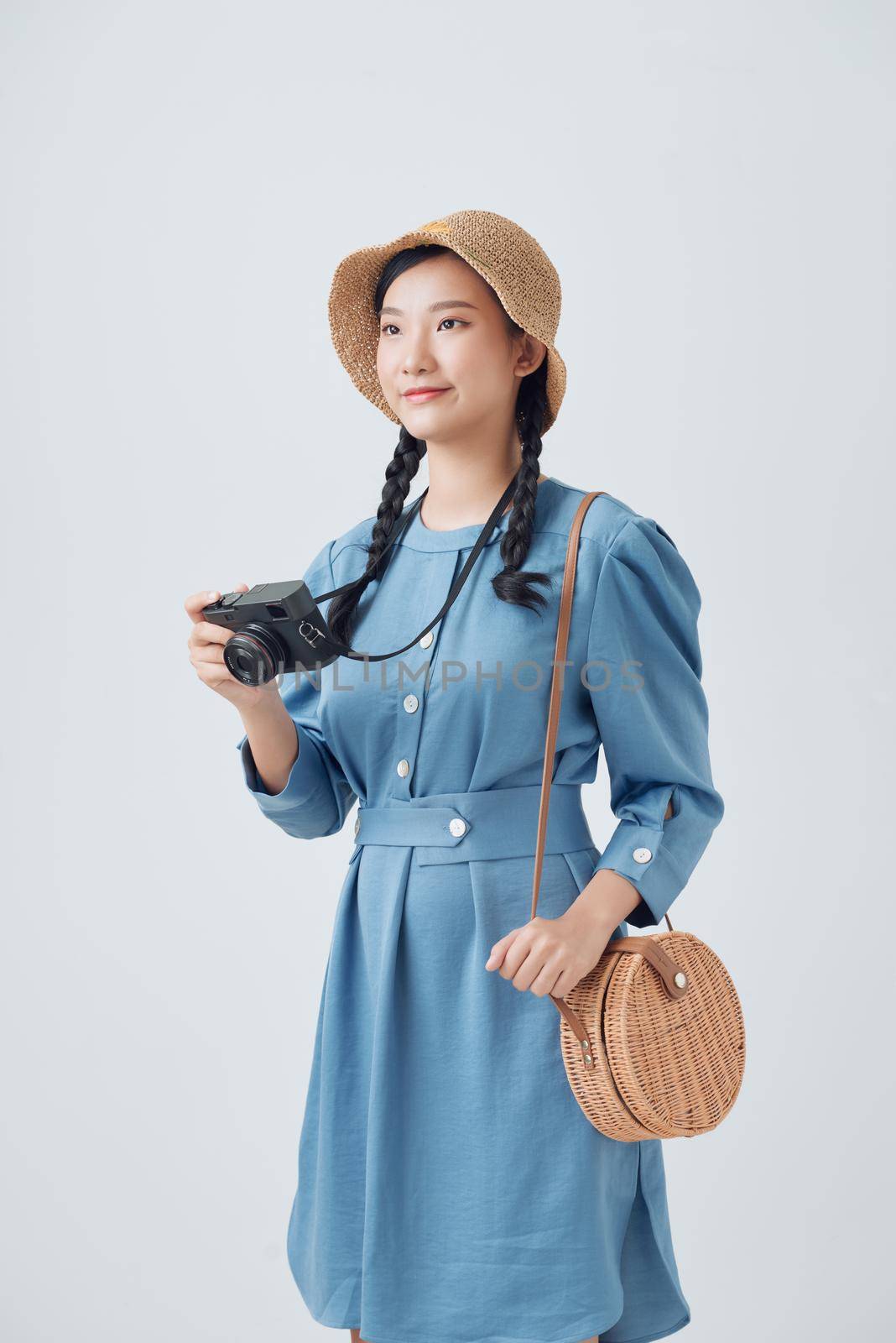 Young female photographer on white background