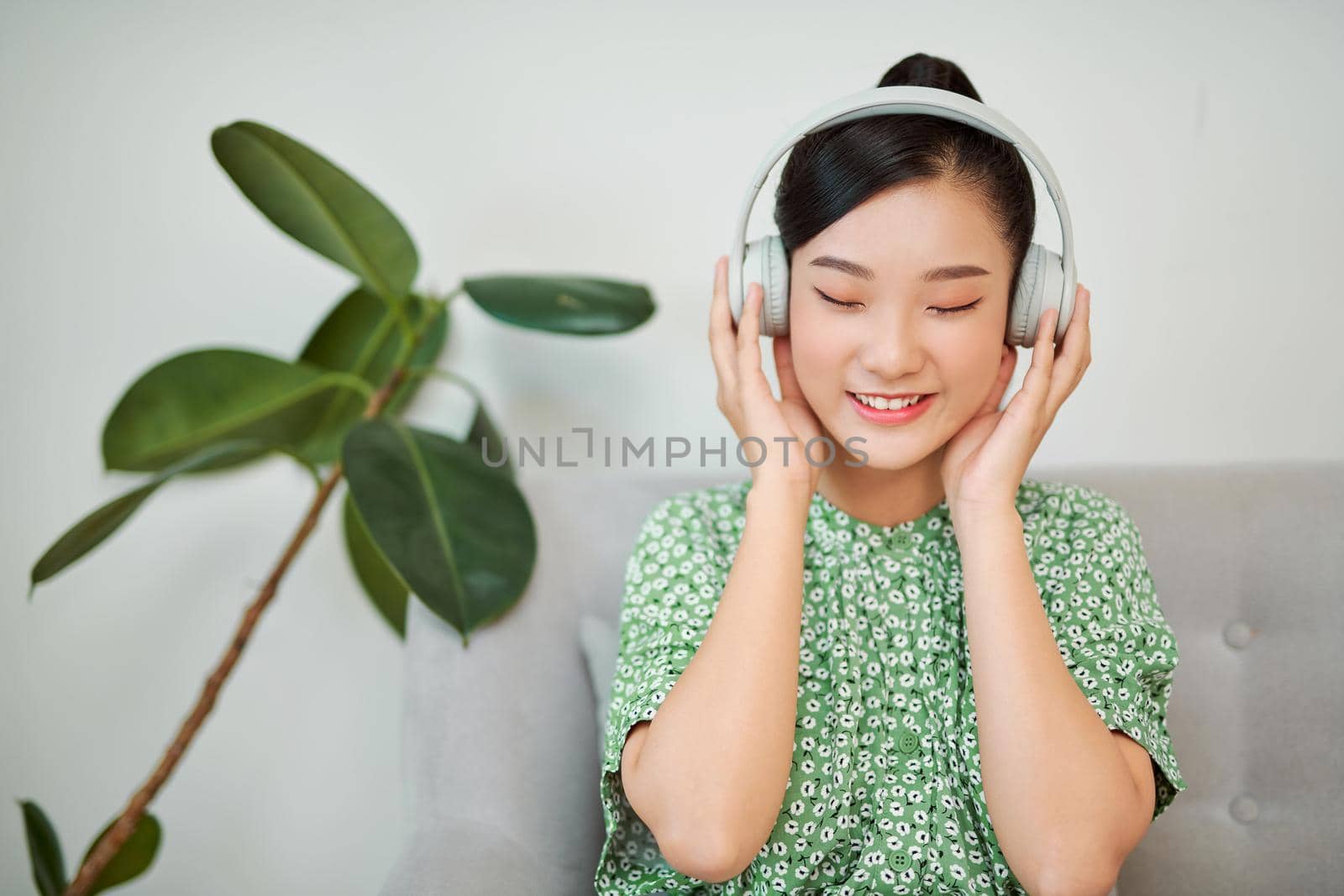 Asian woman listening to music with headphones at home Wireless Technology with Copy space. 