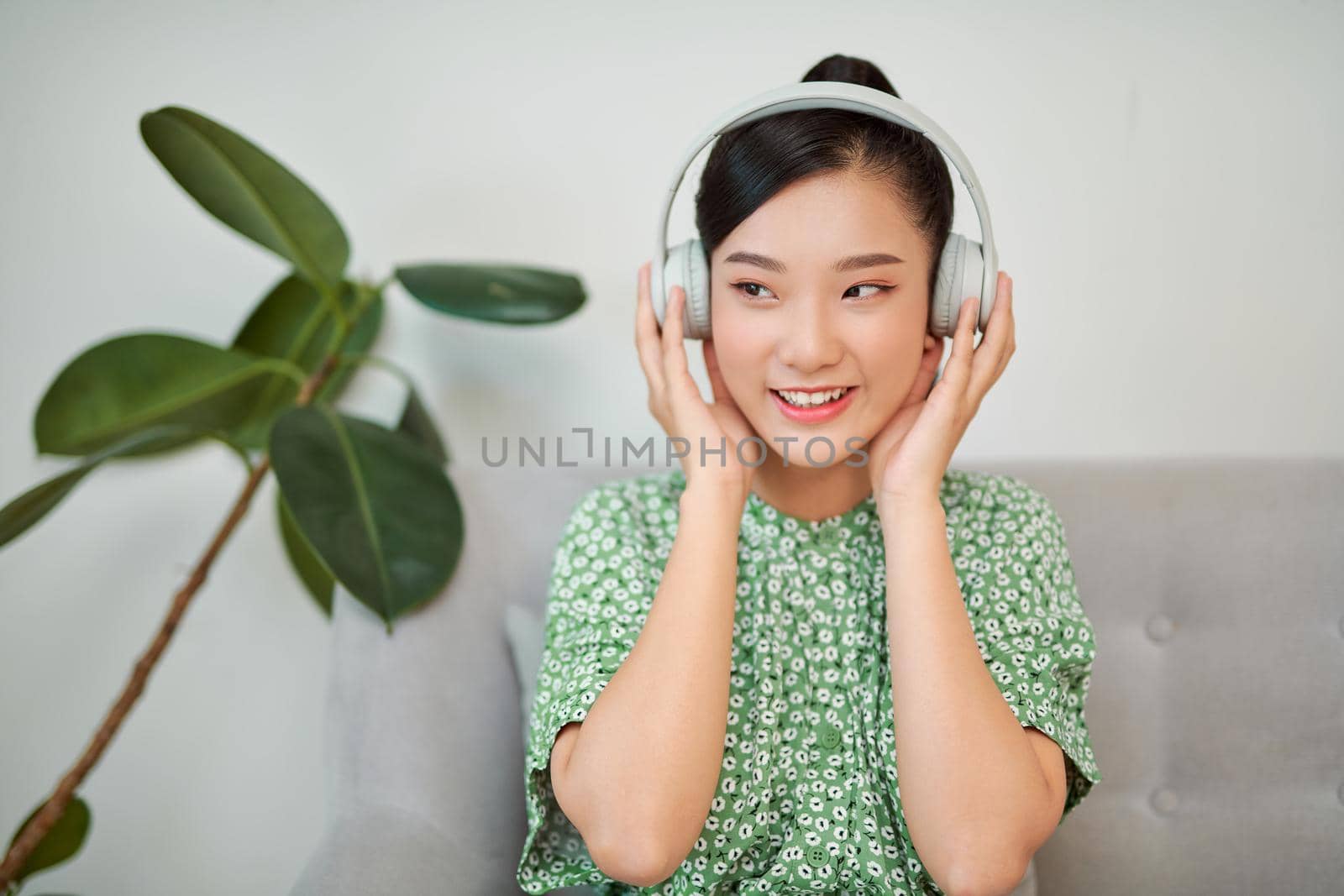 Young woman listening to music while relaxing on sofa at home