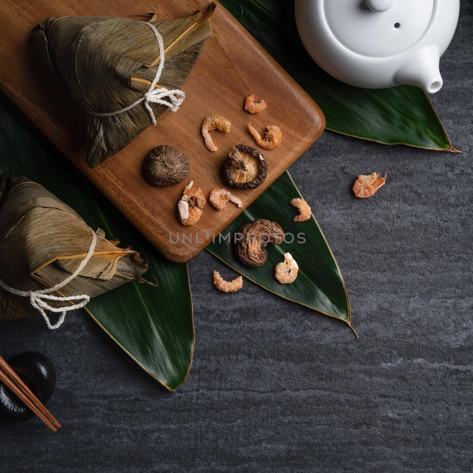 Zongzi. Rice dumpling top view design concept for Chinese traditional Dragon Boat Festival (Duanwu Festival) over dark black slate background.