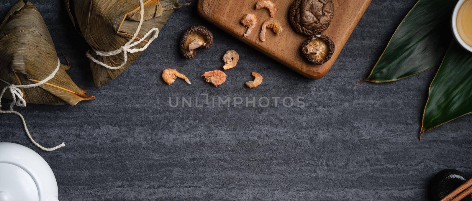 Zongzi. Rice dumpling top view design concept for Chinese traditional Dragon Boat Festival (Duanwu Festival) over dark black slate background.