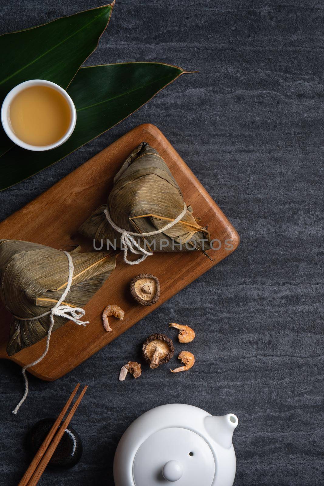 Zongzi. Rice dumpling top view design concept for Chinese traditional Dragon Boat Festival (Duanwu Festival) over dark black slate background.