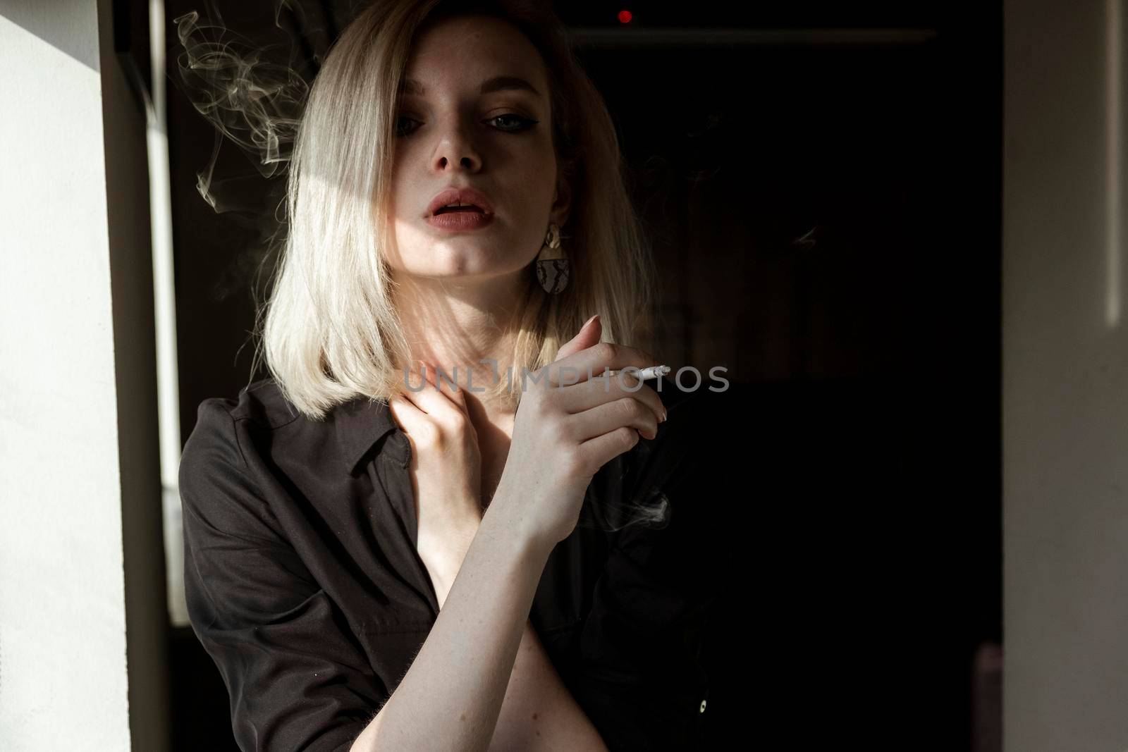 Close-Up Of Young Woman Smoking Cigarette By Window