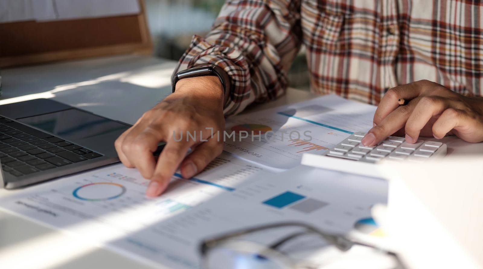 Businessman hands holding pen working on calculator and financial paperwork. by wichayada