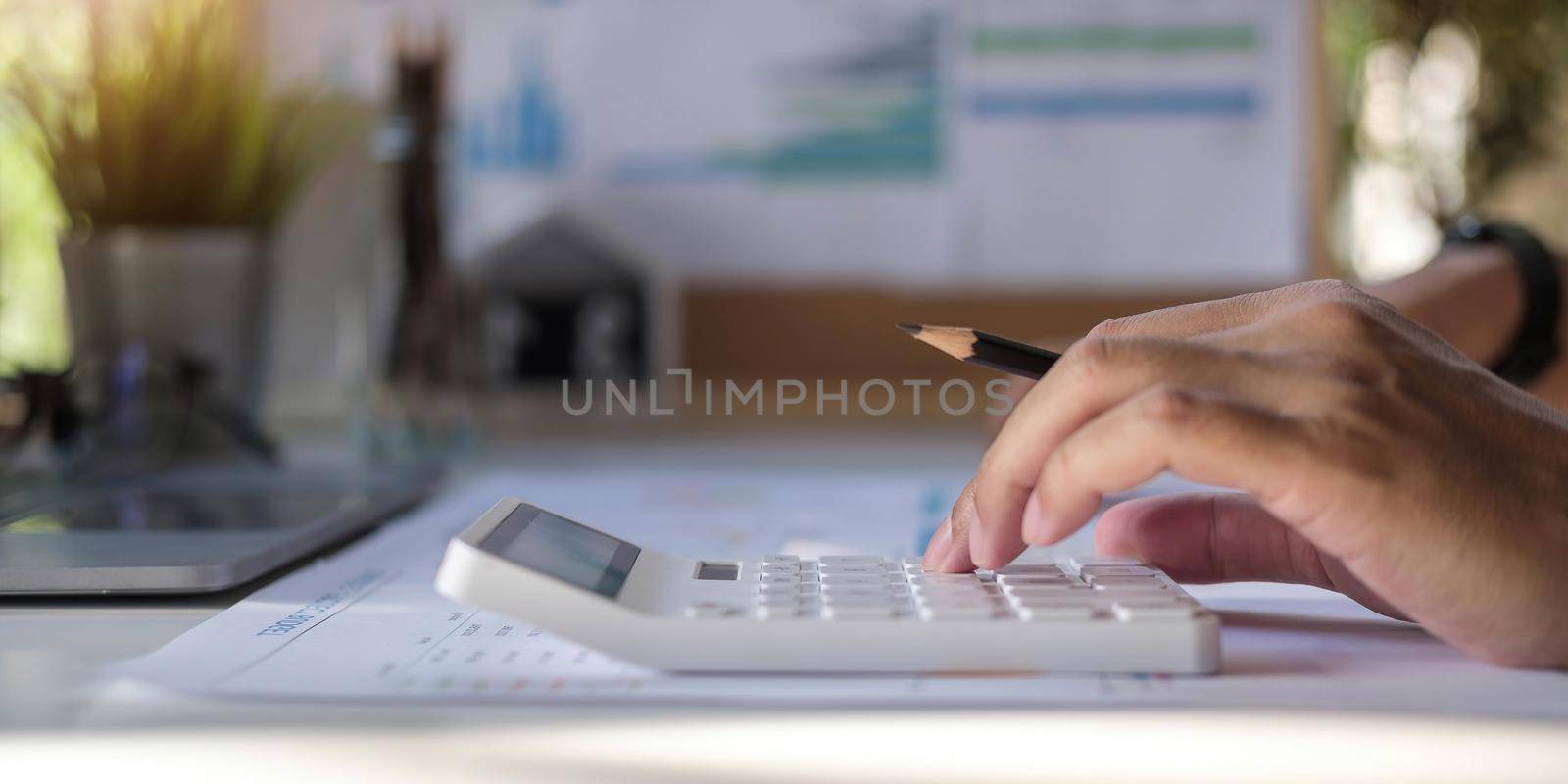Close-up Of A Businessman Calculating Invoice Using Calculator At Workplace.