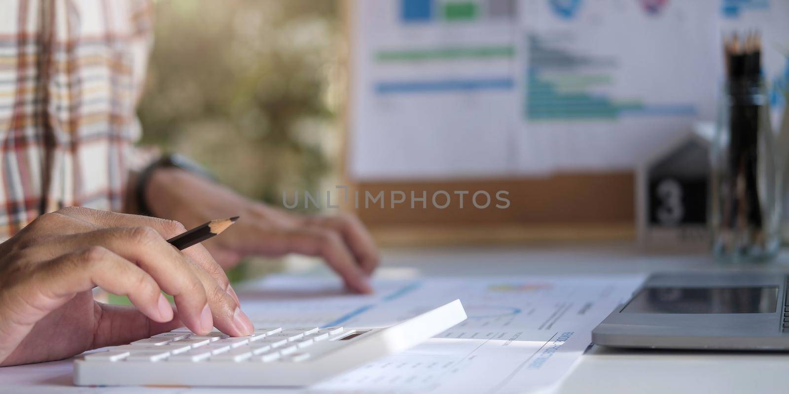 Close-up Of A Businessman Calculating Invoice Using Calculator At Workplace.