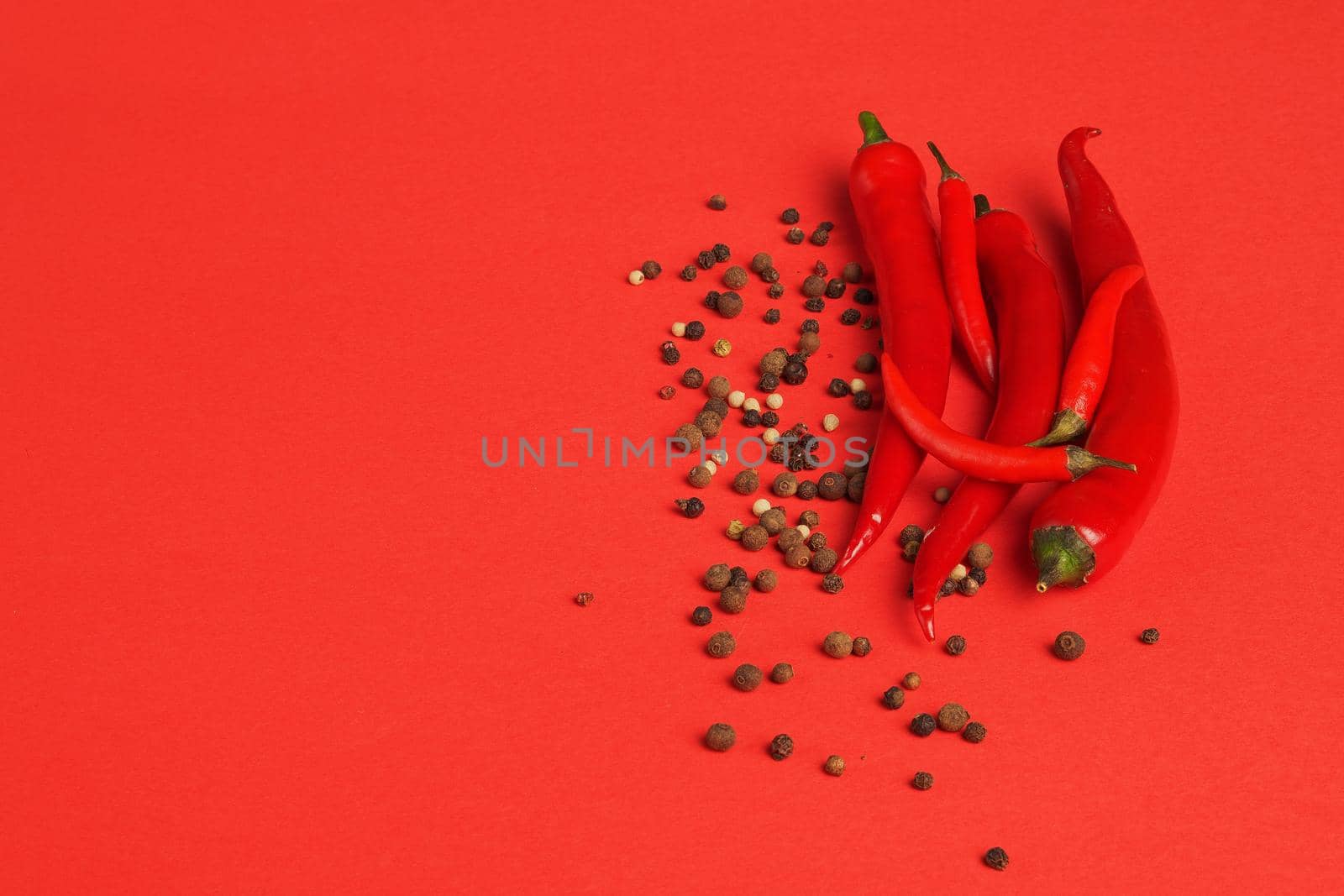 Food and spices. Red chili pepper and pepper pot on red background. High quality photo