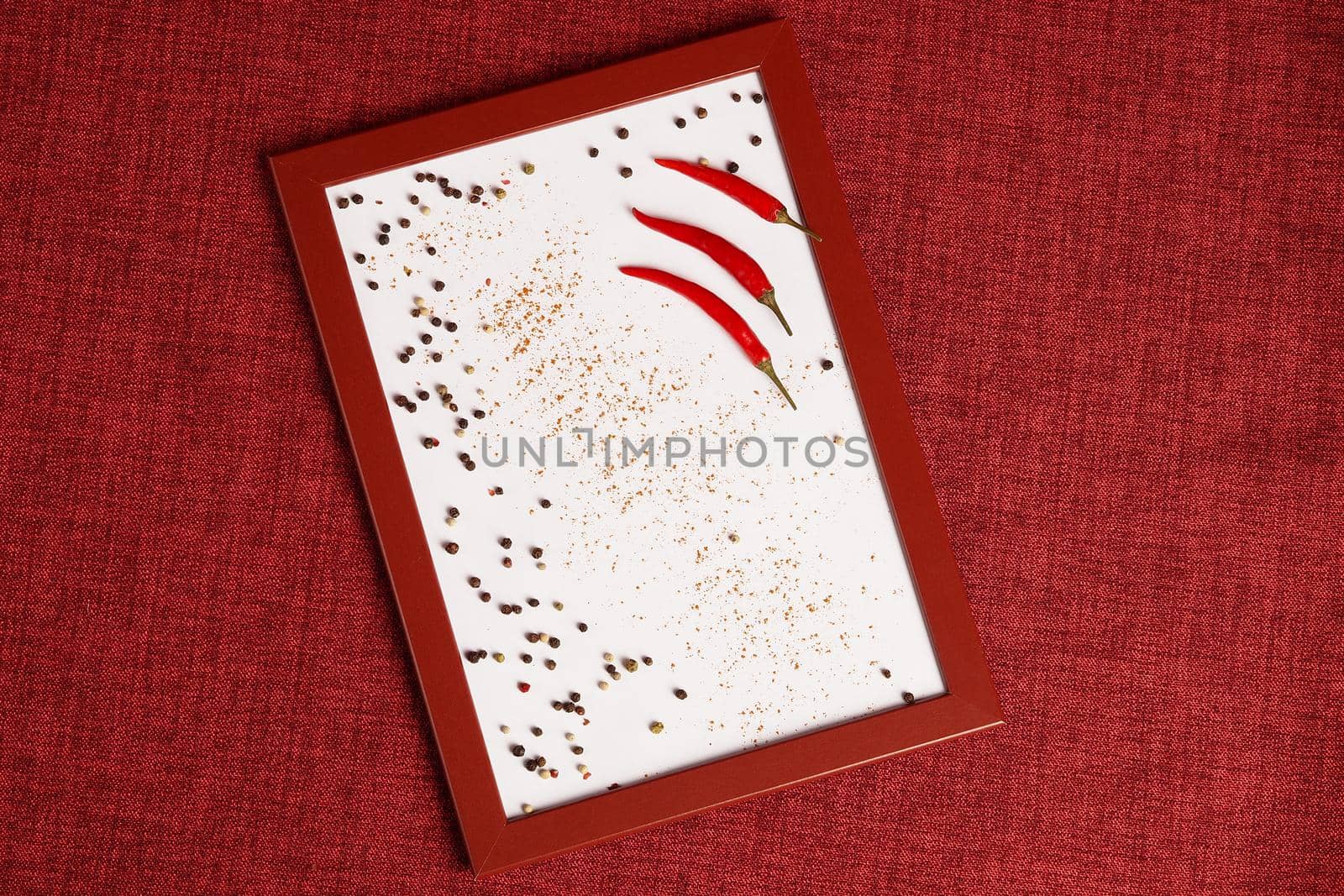 Photo of a red chili pepper in a frame. Spices for cooking in the photo. by Olga26