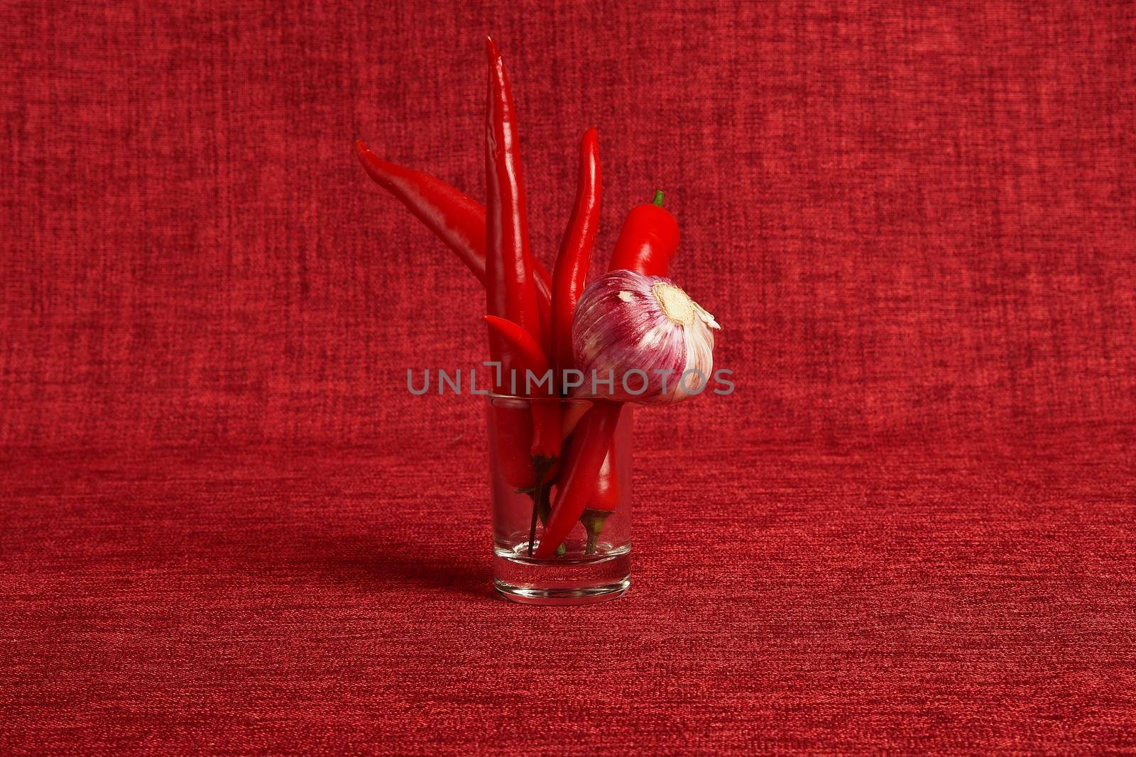 Ripe vegetables. Red pepper and fresh garlic on a red background. High quality photo