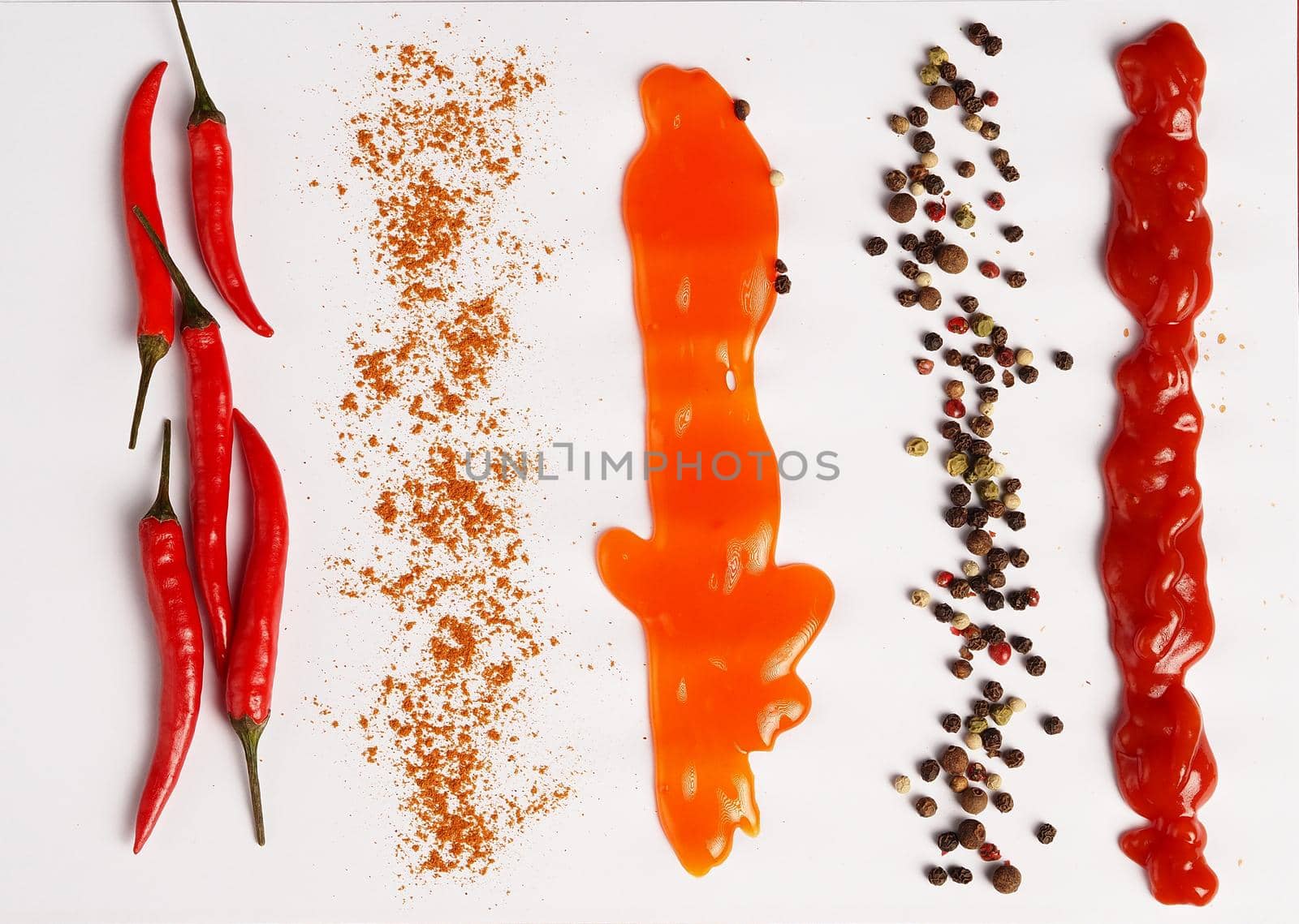 Chili peppers, spices and sauces on a white background. close-up. by Olga26