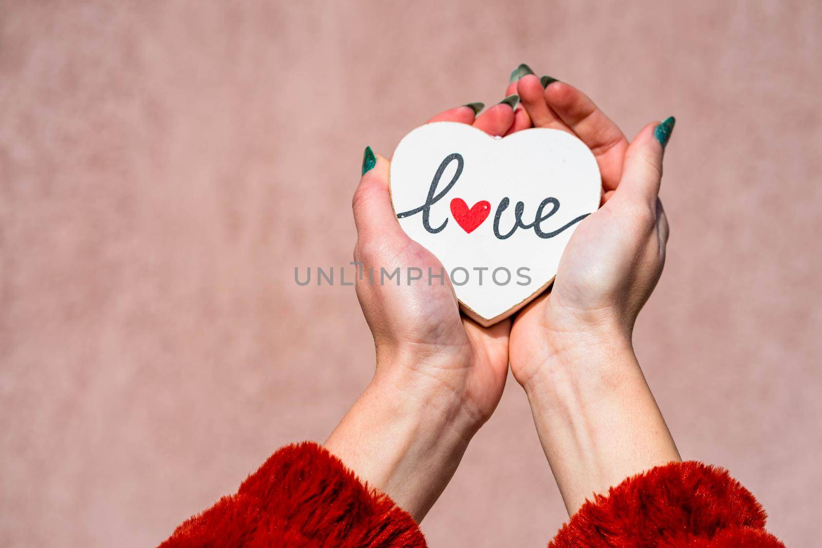 Hands holding heart with love message text.