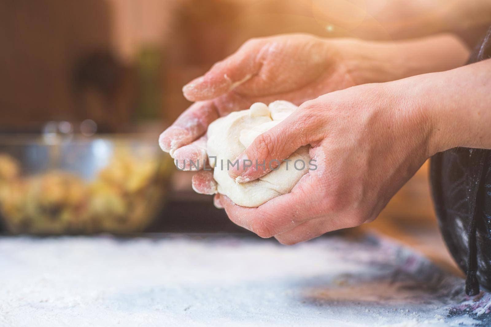 Close up of woman kneading traditional dough in the kitchen