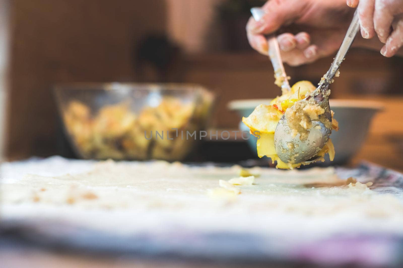 Close up of woman preparing traditional Austrian apple strudel in the kitchen