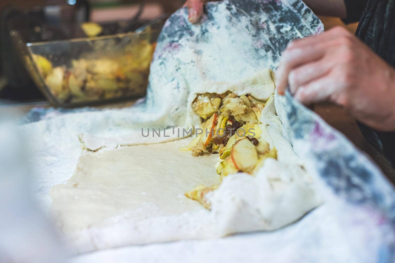Close up of woman preparing traditional Austrian apple strudel in the kitchen