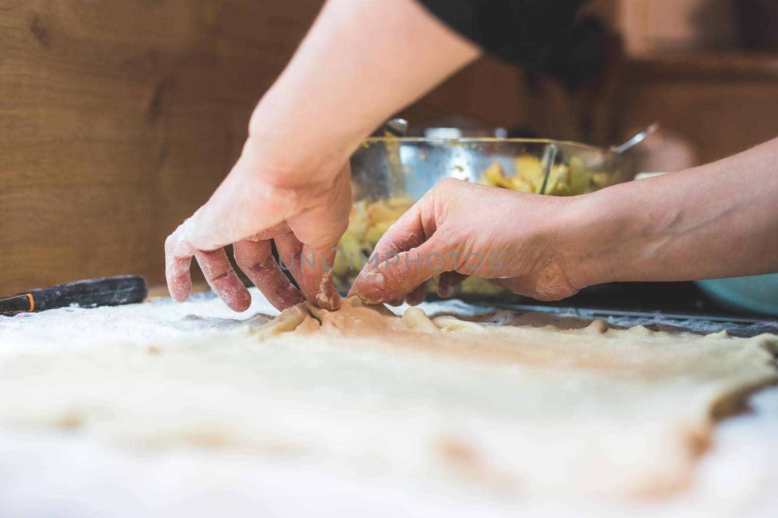 Close up of woman rolling traditional dough in the kitchen