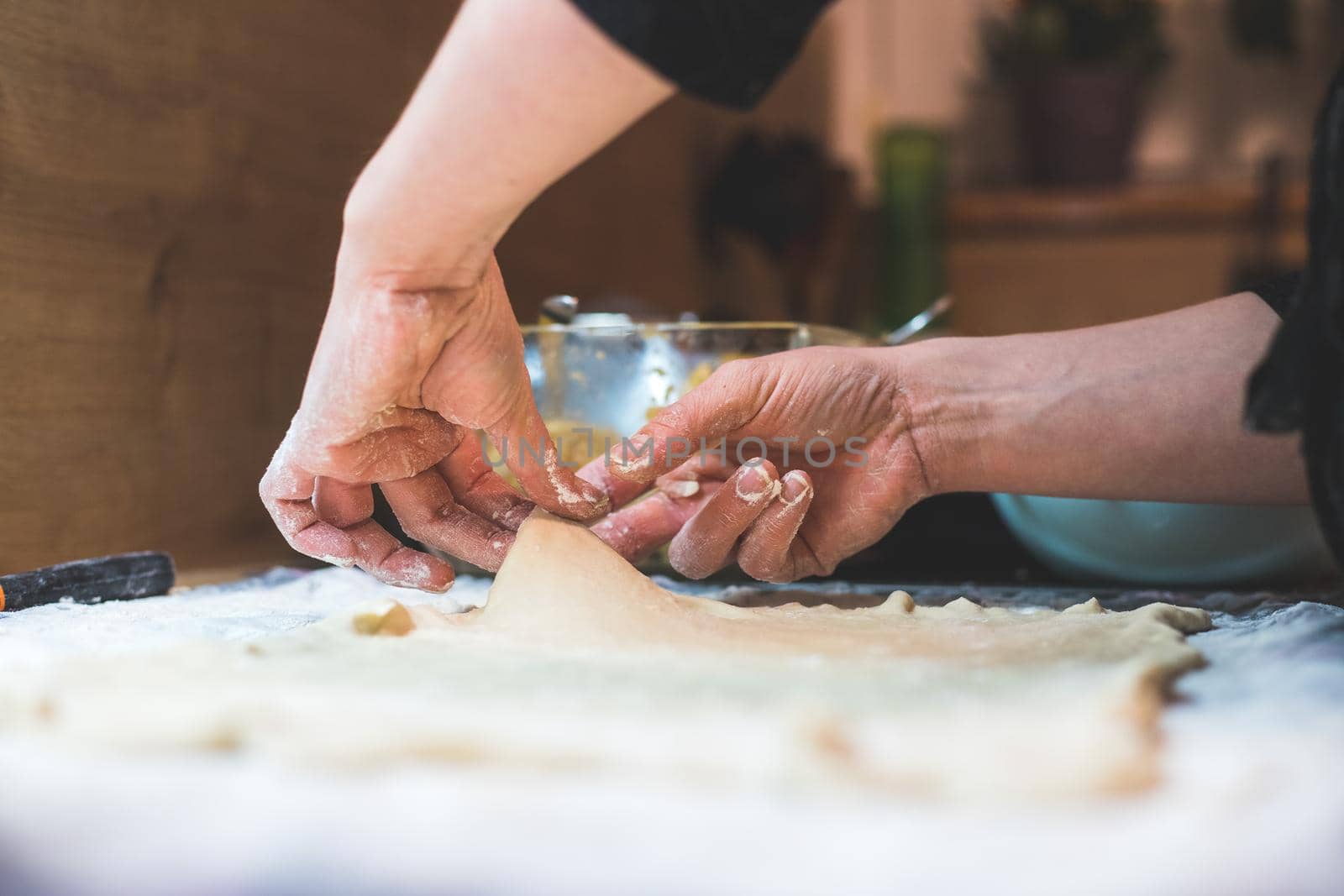 Close up of woman rolling traditional dough in the kitchen