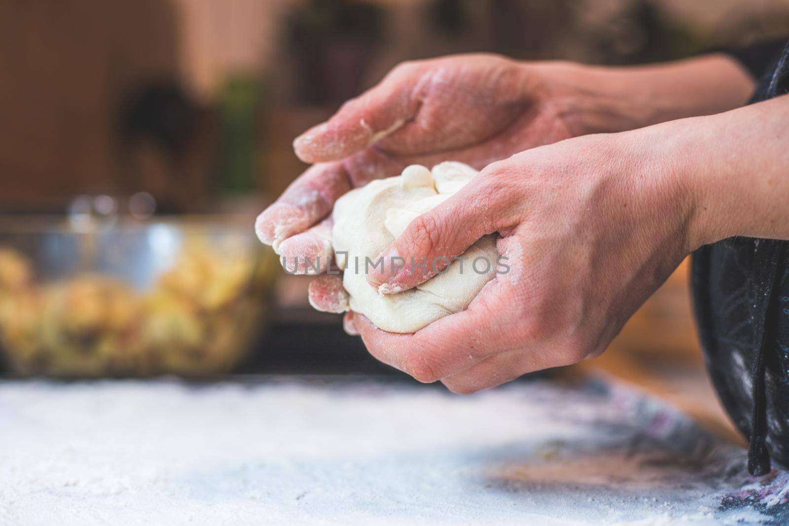 Close up of woman kneading traditional dough in the kitchen