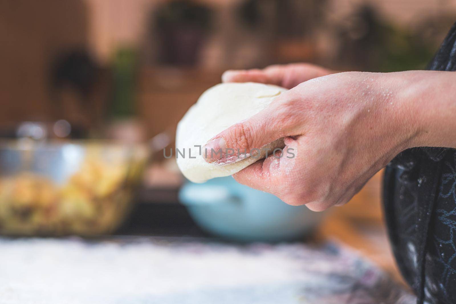 Close up of woman kneading traditional dough in the kitchen