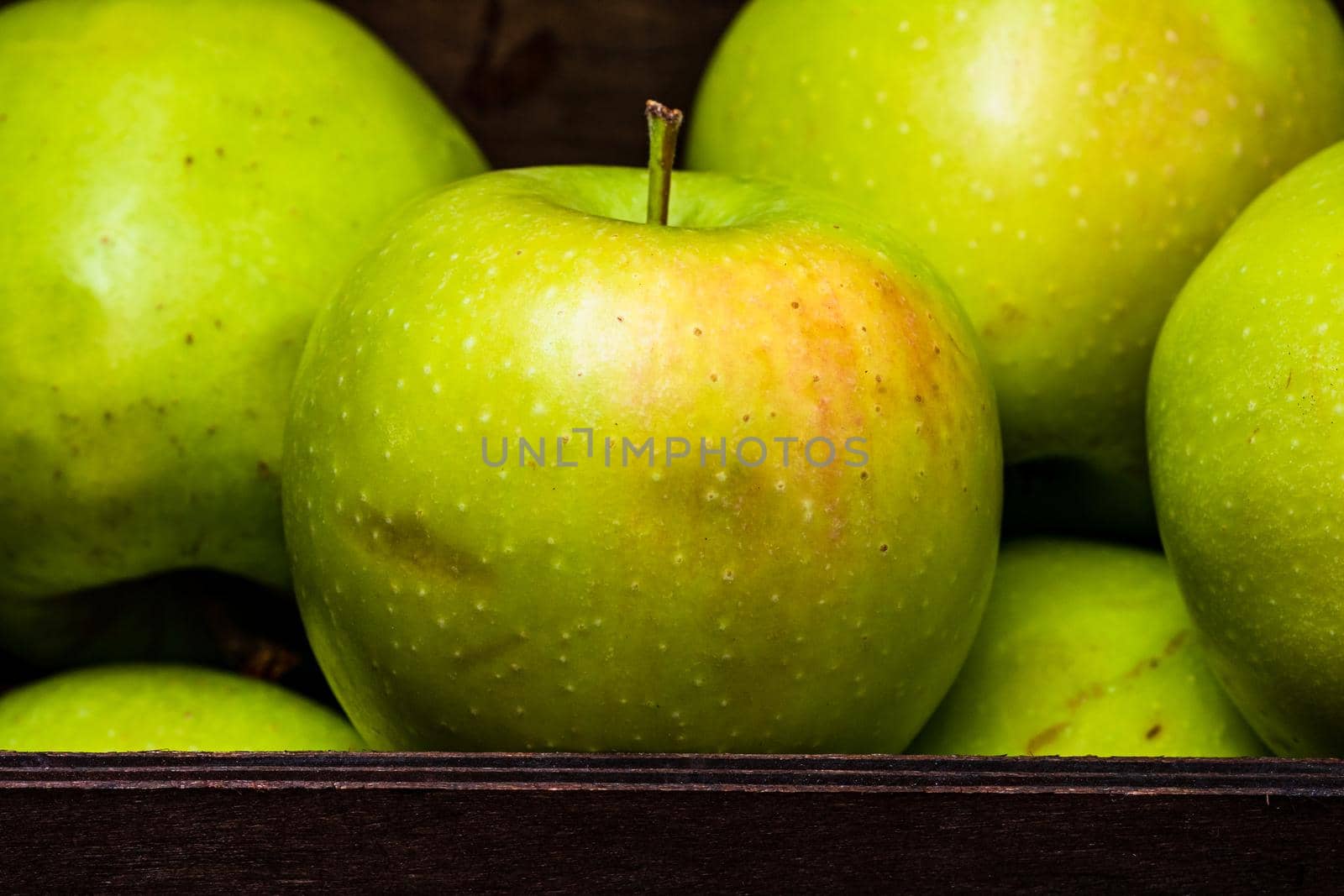  Ripe green apples in a wooden crate, close up isolated. by vladispas