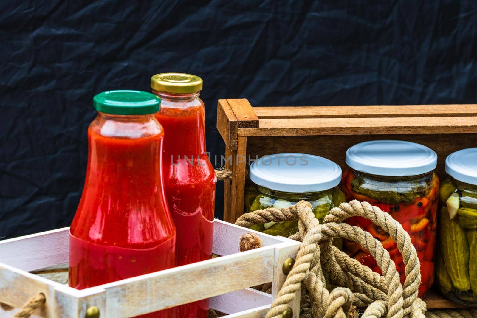 Bottles of tomato sauce, preserved canned pickled food concept isolated in a rustic composition.