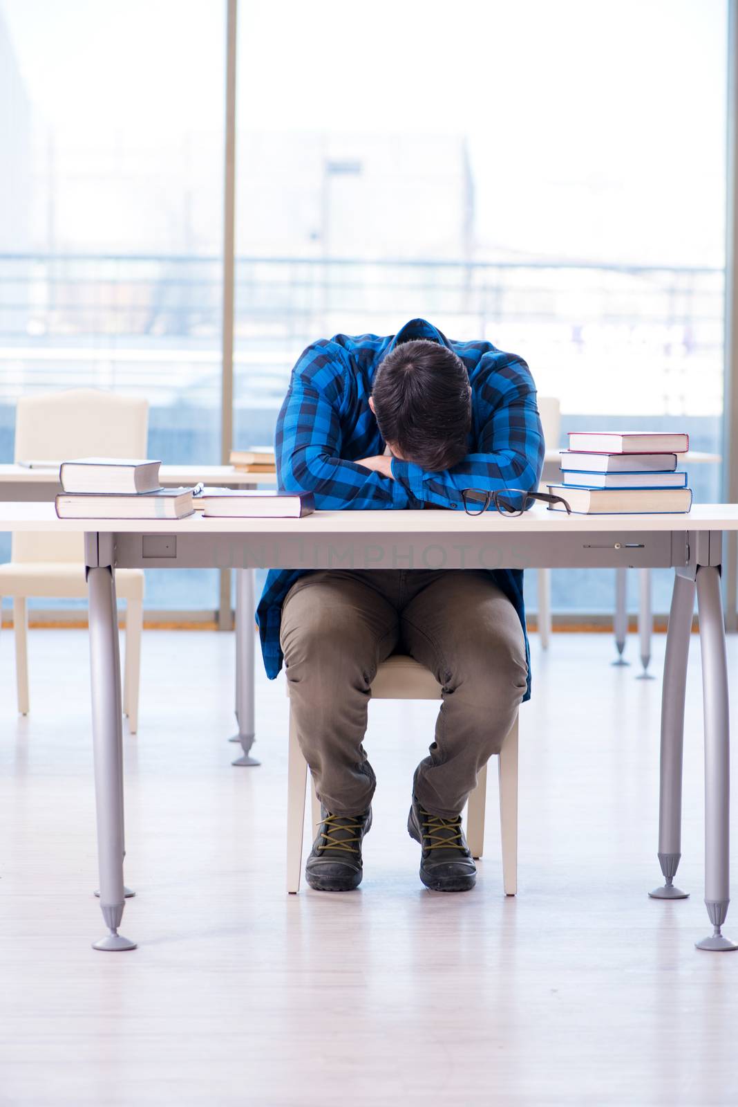 Student studying in the empty library with book preparing for exam