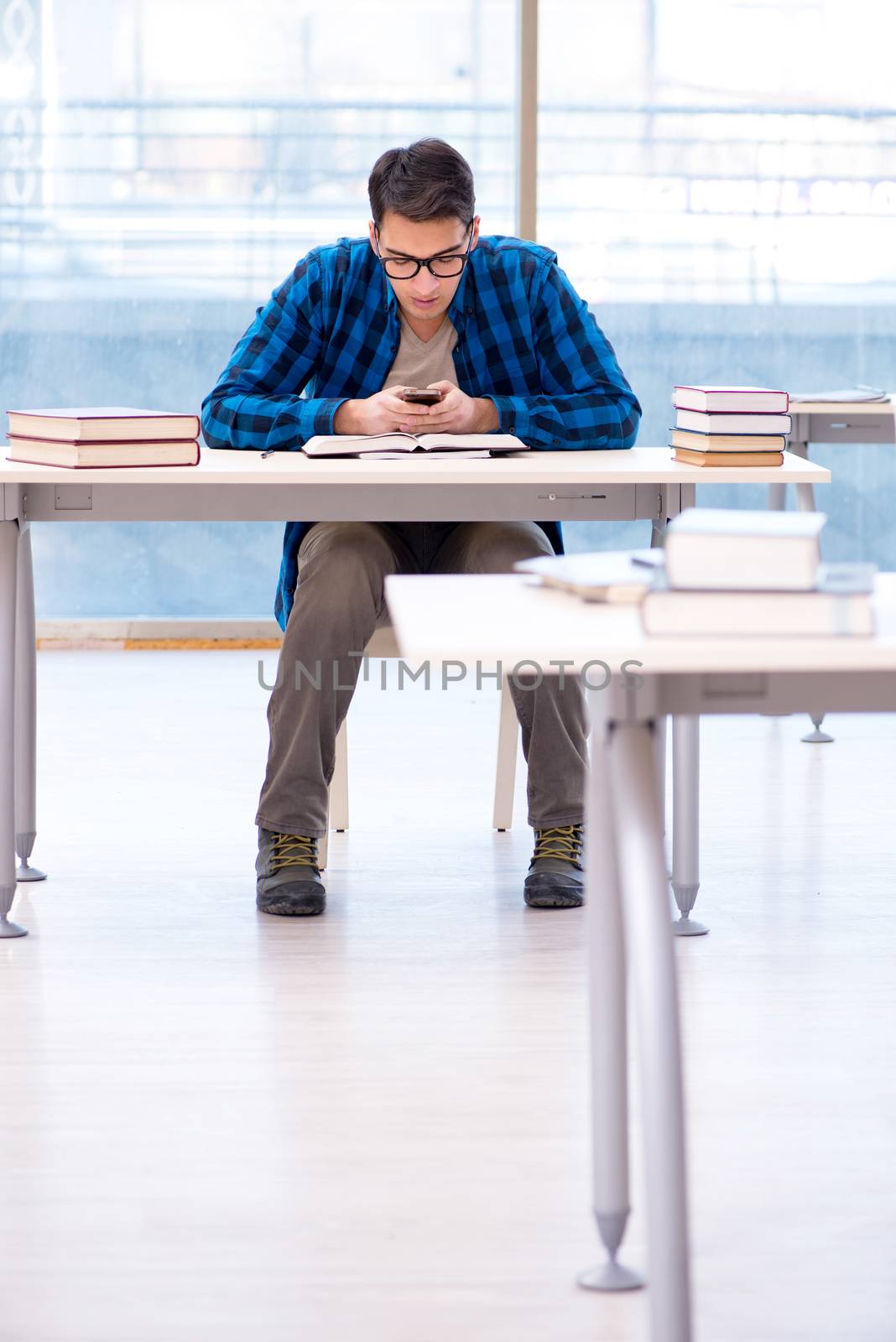 Student studying in the empty library with book preparing for exam