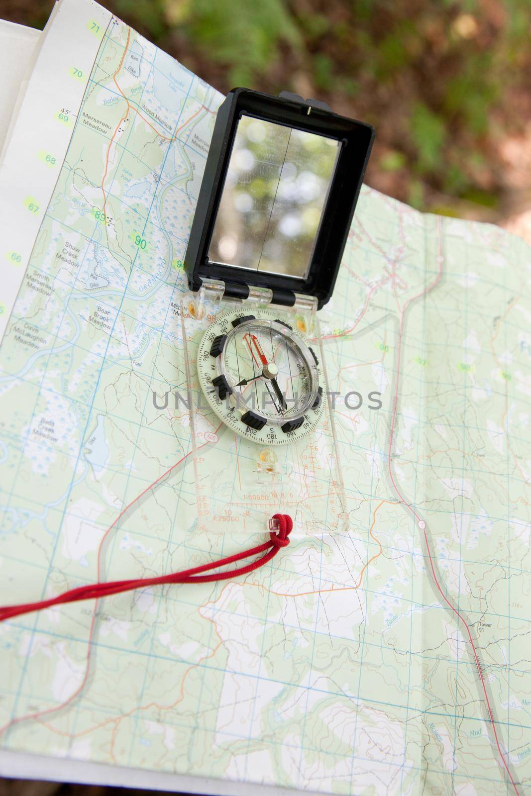 Outside a map with a digital compass shows the direction for a traveler in the forest 