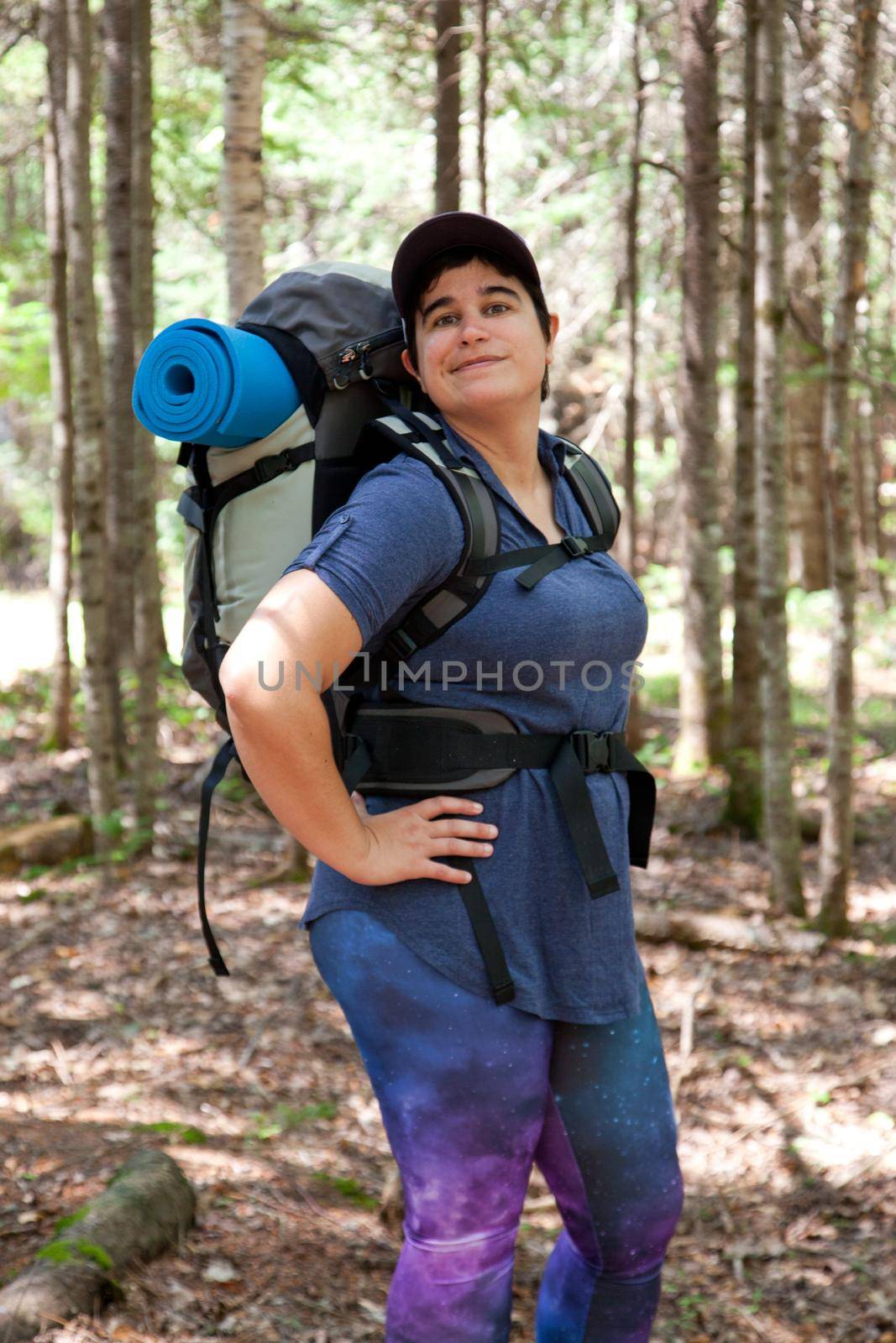 A woman stands in the woods looking ready for any challenge or adventure 
