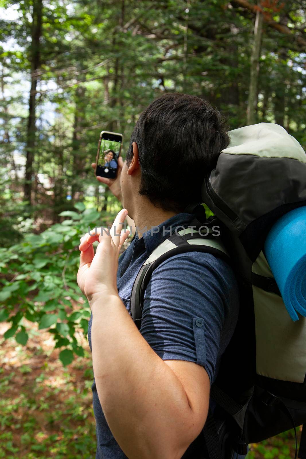 person stops for a social media selfie while hiking in the woods 