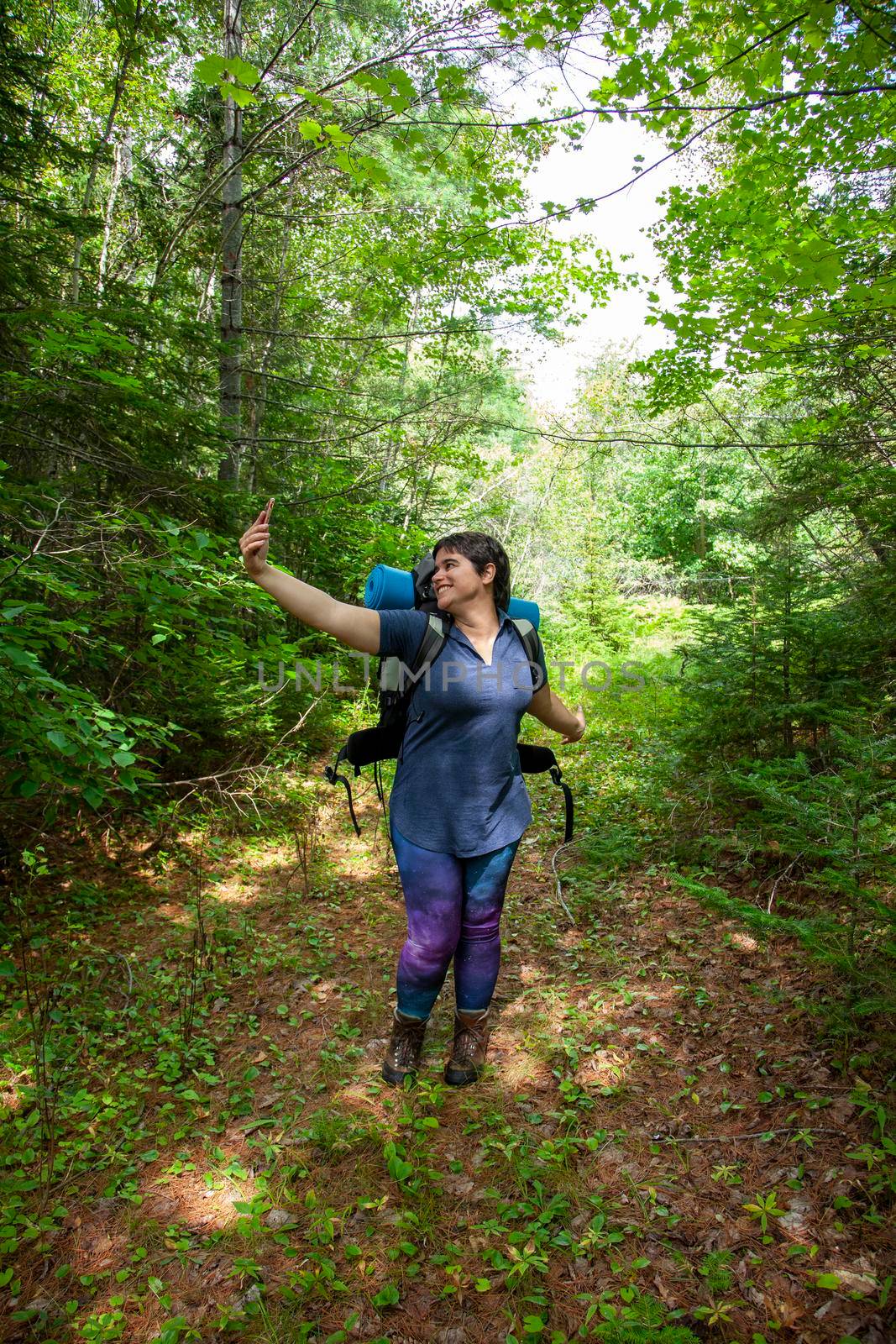  stopping while hiking outdoors to pose for a self portrait or selfie