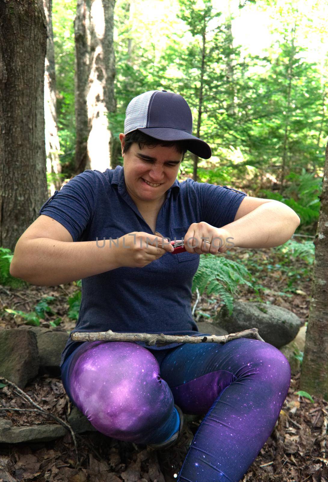 Person in the woods using a multi tool or knife 