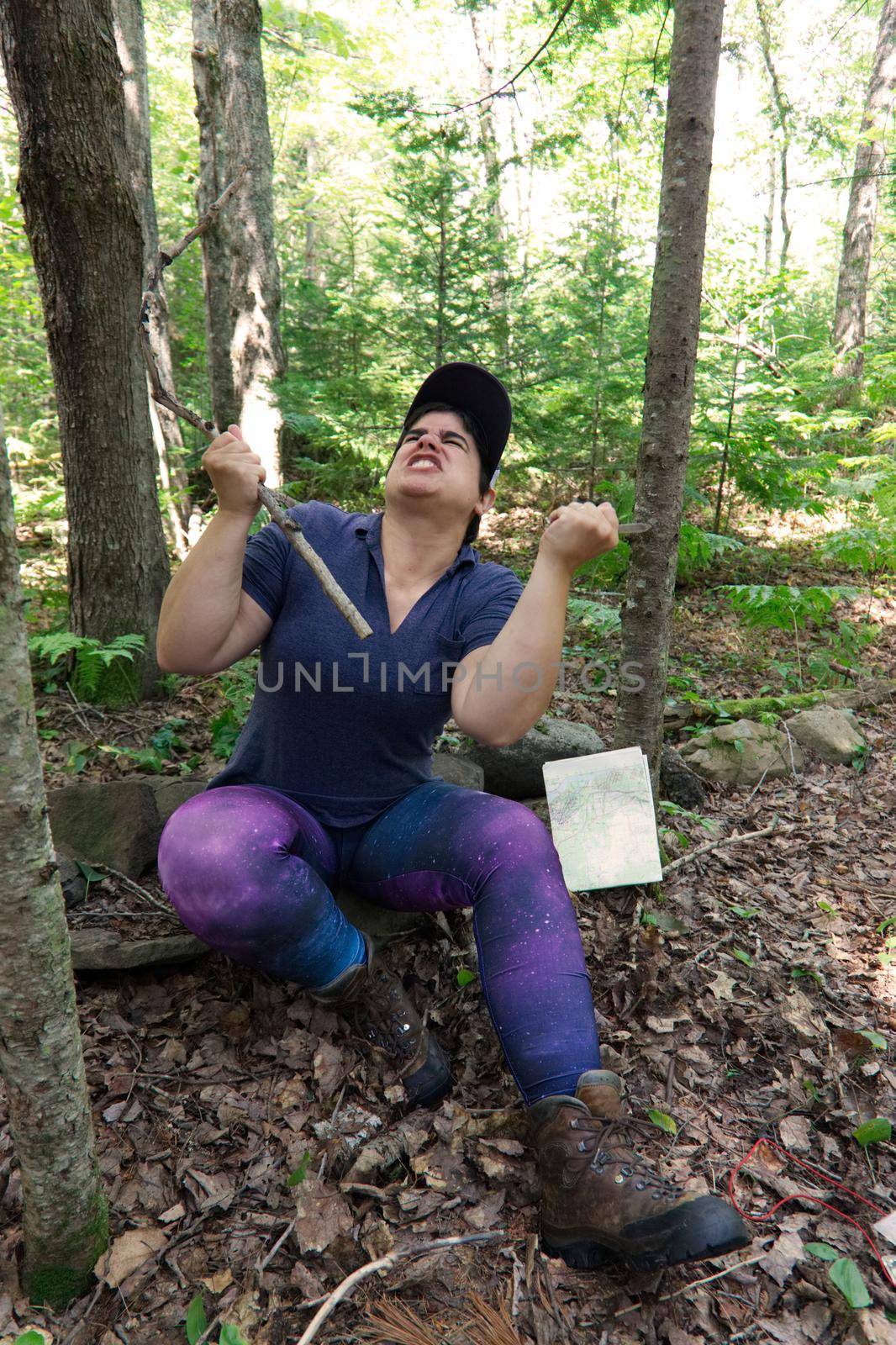 Person holding a stick and a knife shouting at the heavens in the woods while camping