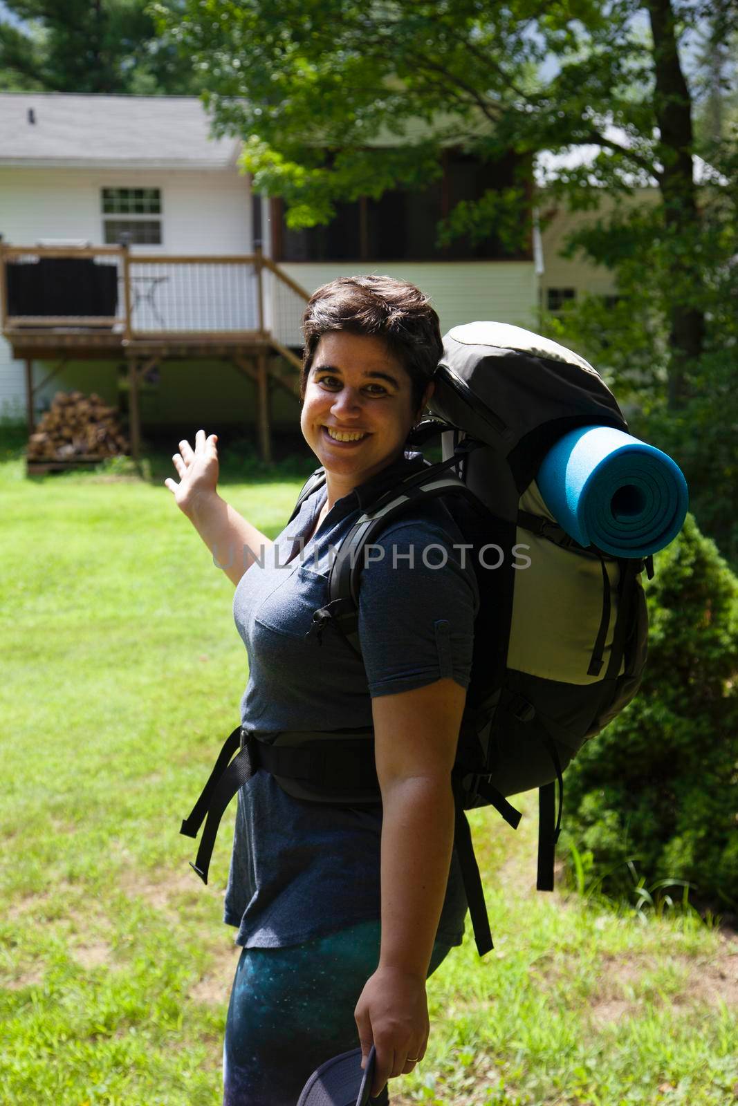 person with a backpack is smiling and ready to leave home on an adventure 