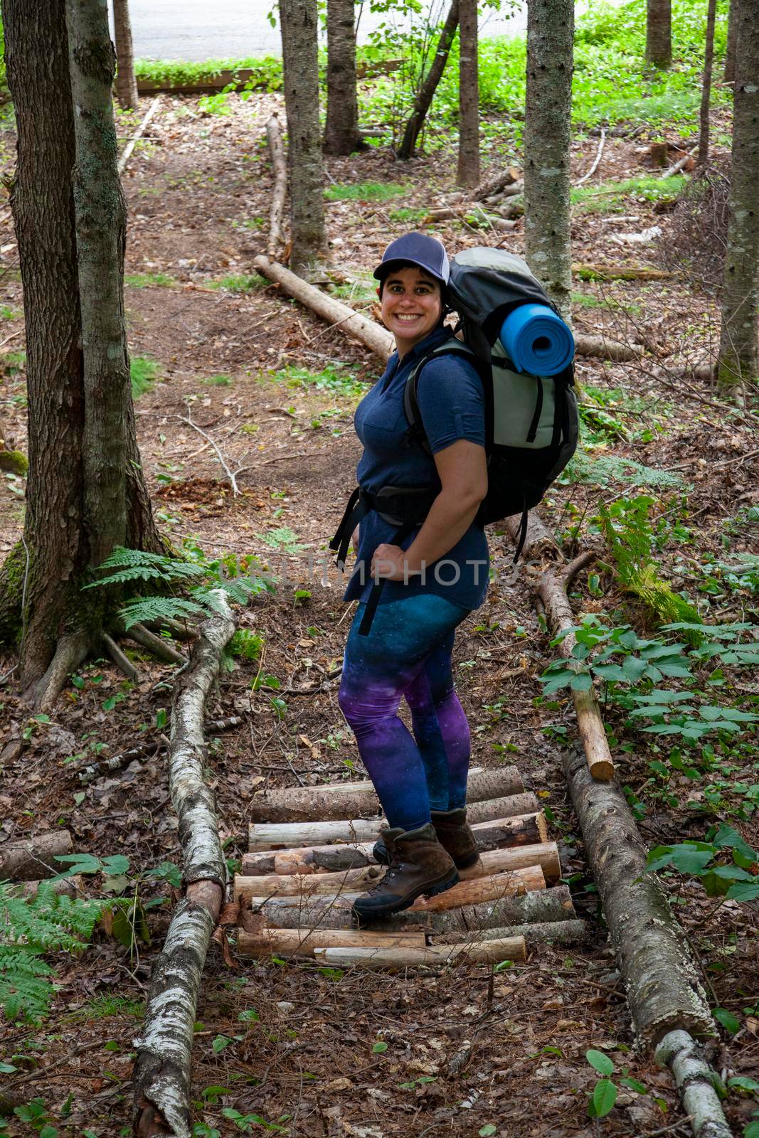 smiling woman on a wooded path or trail 