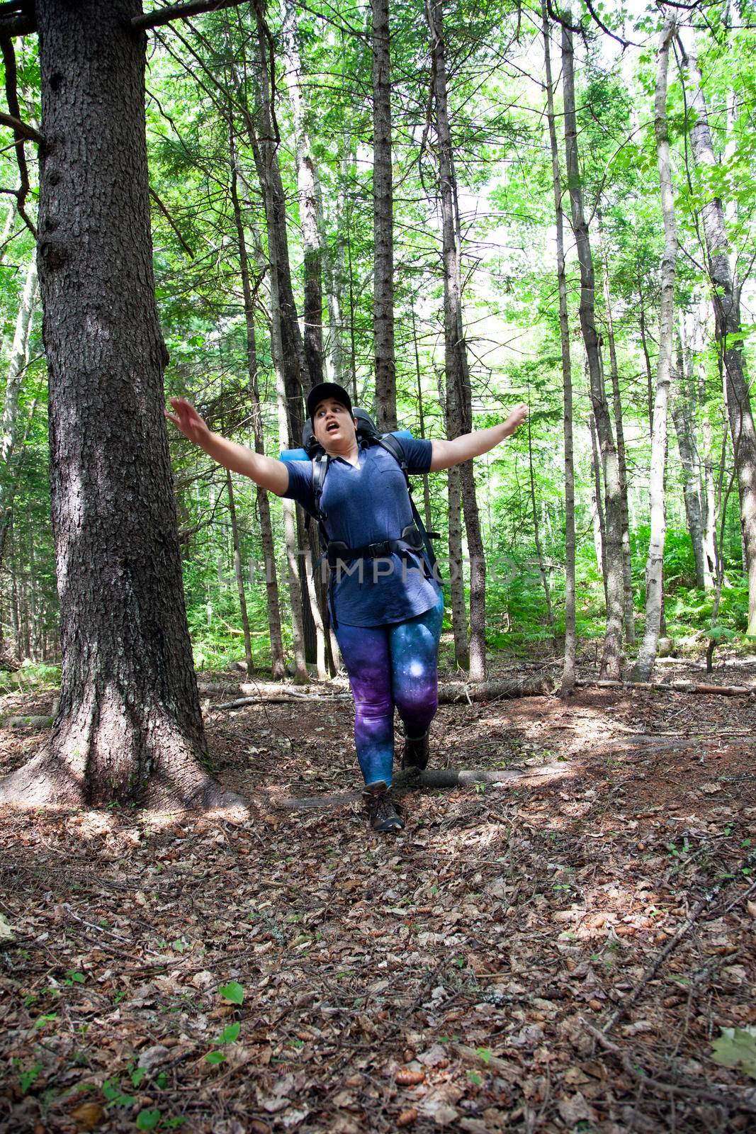 hiker falls over a root in the ground while hiking in the forest 