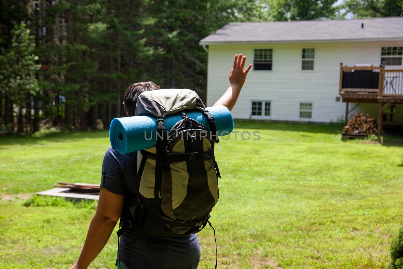  person loking back at their house with a backpack ready for adventure 