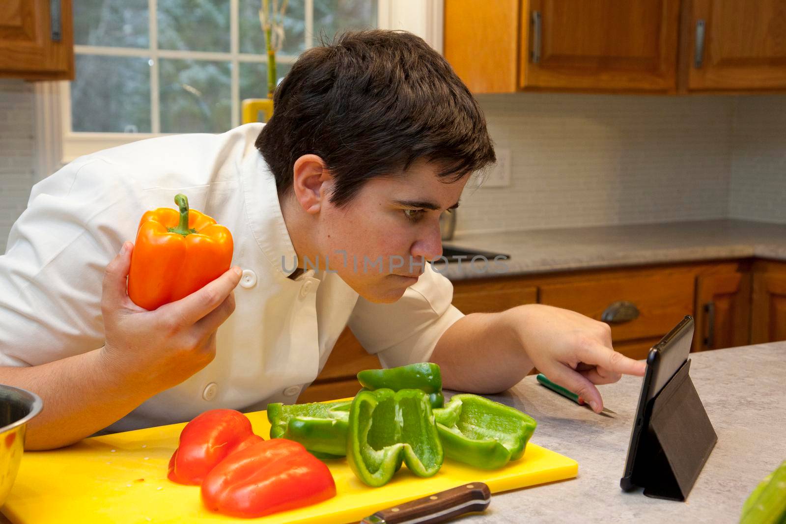 Close view of person in the kitchen looking at their tablet to get help with a cooking recipe