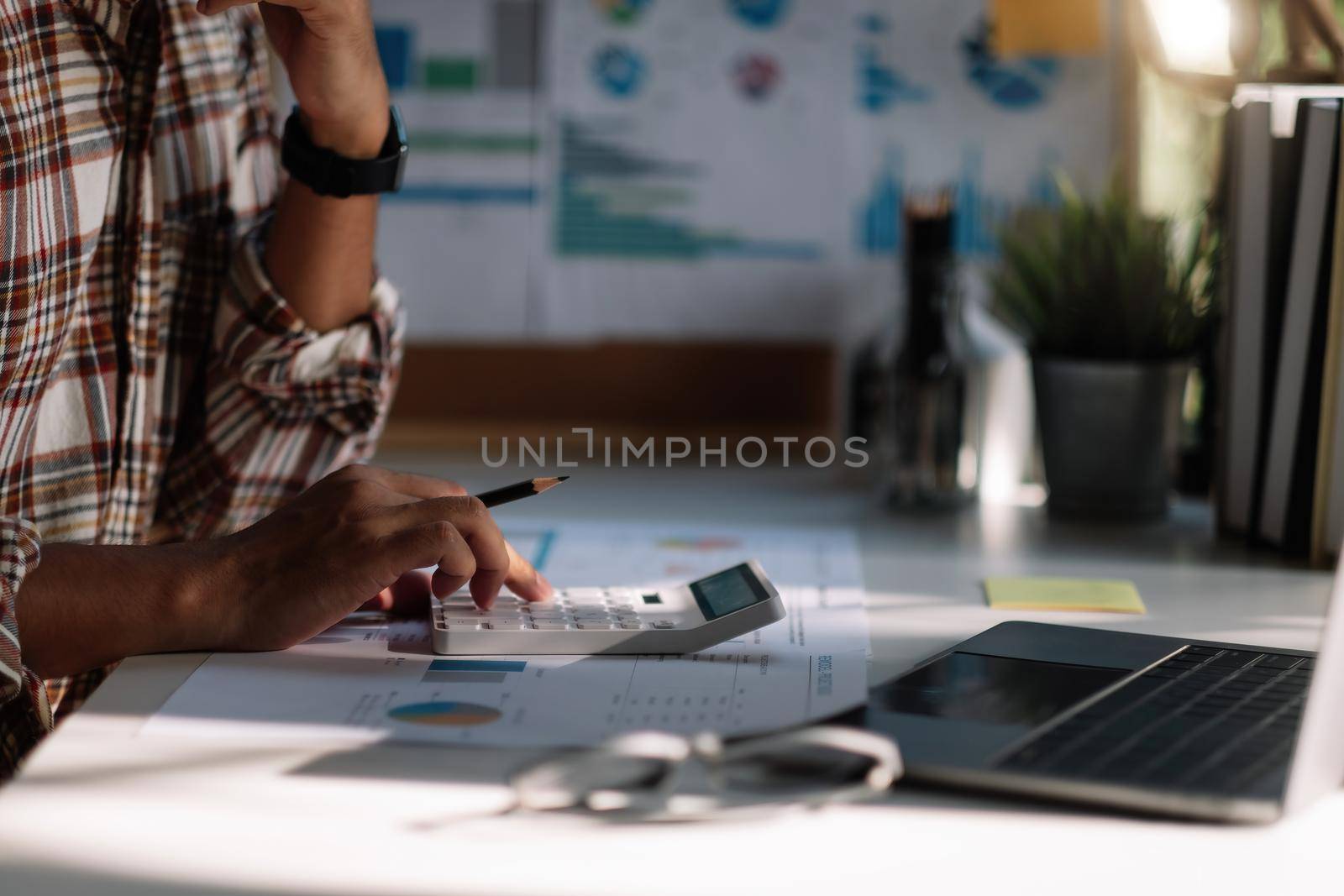 Business accounting concept, A man using calculator with computer laptop, budget and loan paper working at home.