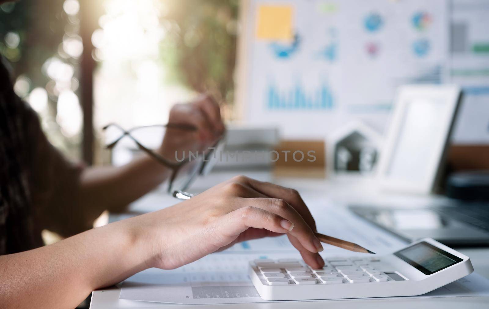 Women using calculator for calculate financial report at home.