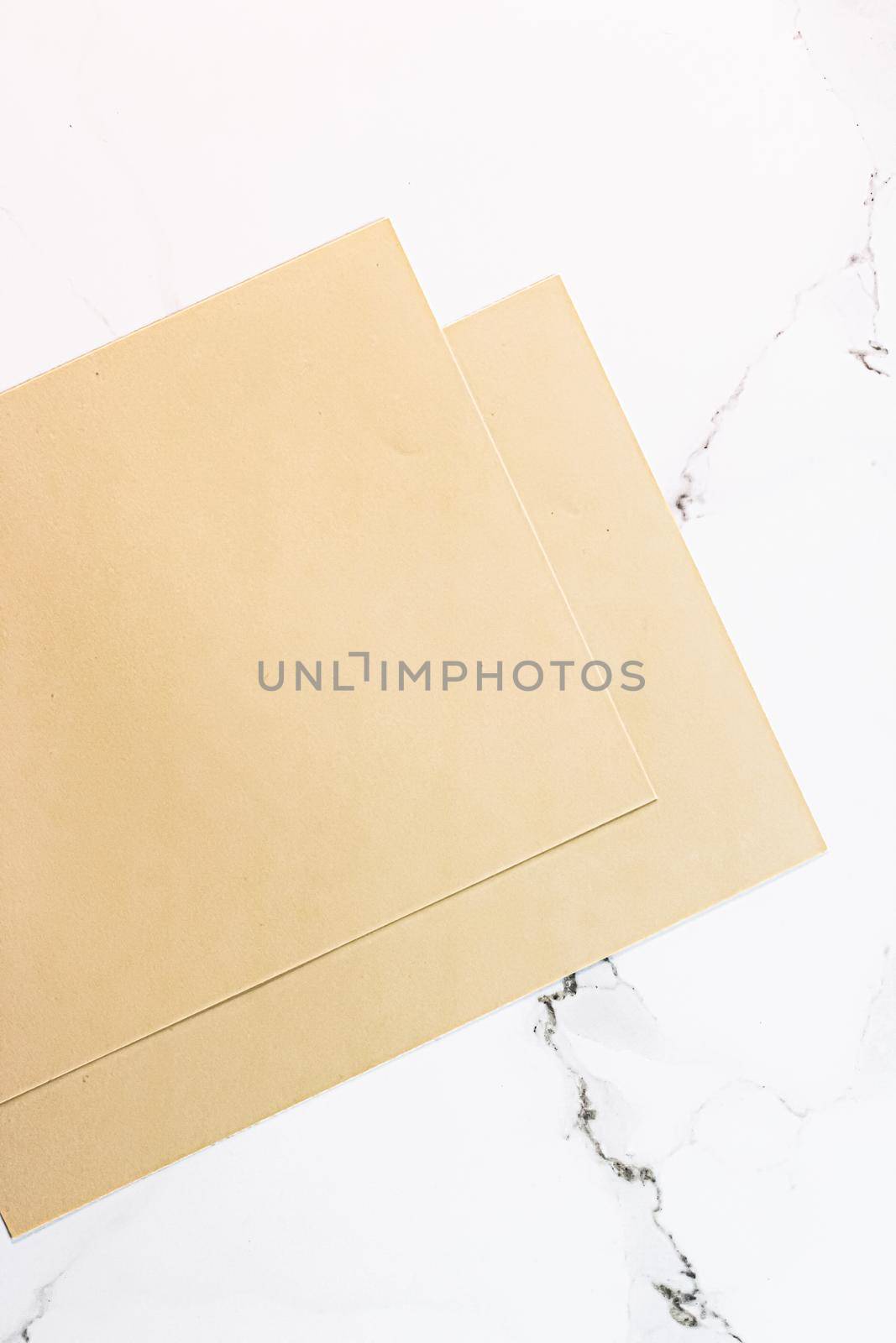 Beige A4 papers on white marble background as office stationery flatlay, luxury branding flat lay and brand identity design for mockup by Anneleven