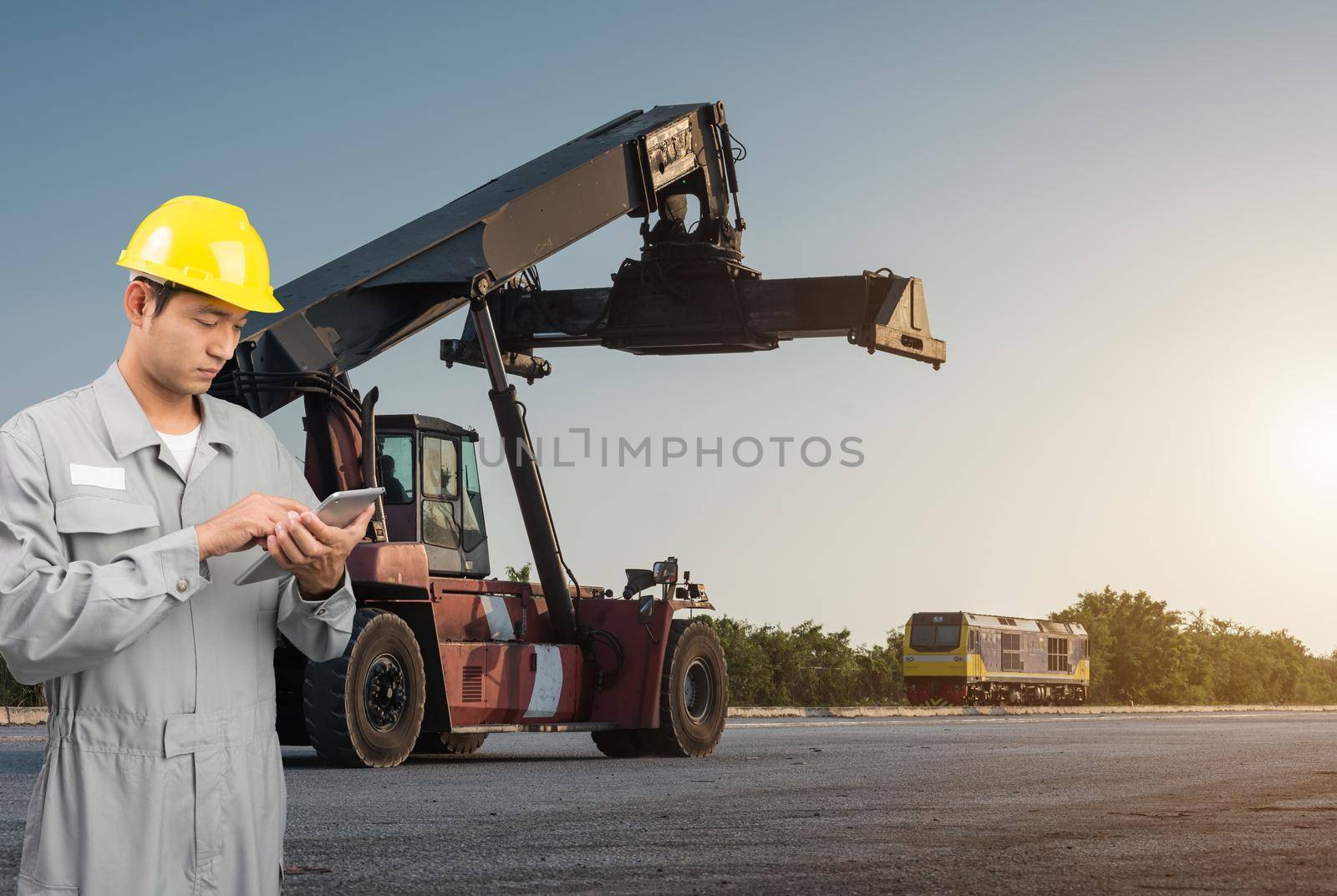 Foreman stand check tablet on front forklift loading Containers box by Sorapop