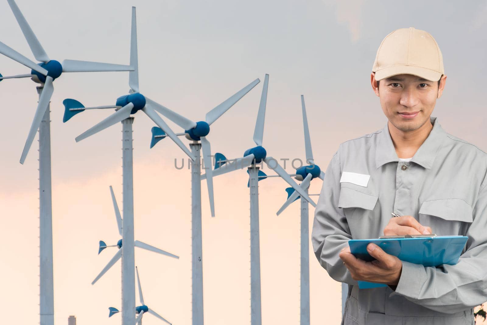 Engineer or technician write book with large Wind Turbine Power Station background