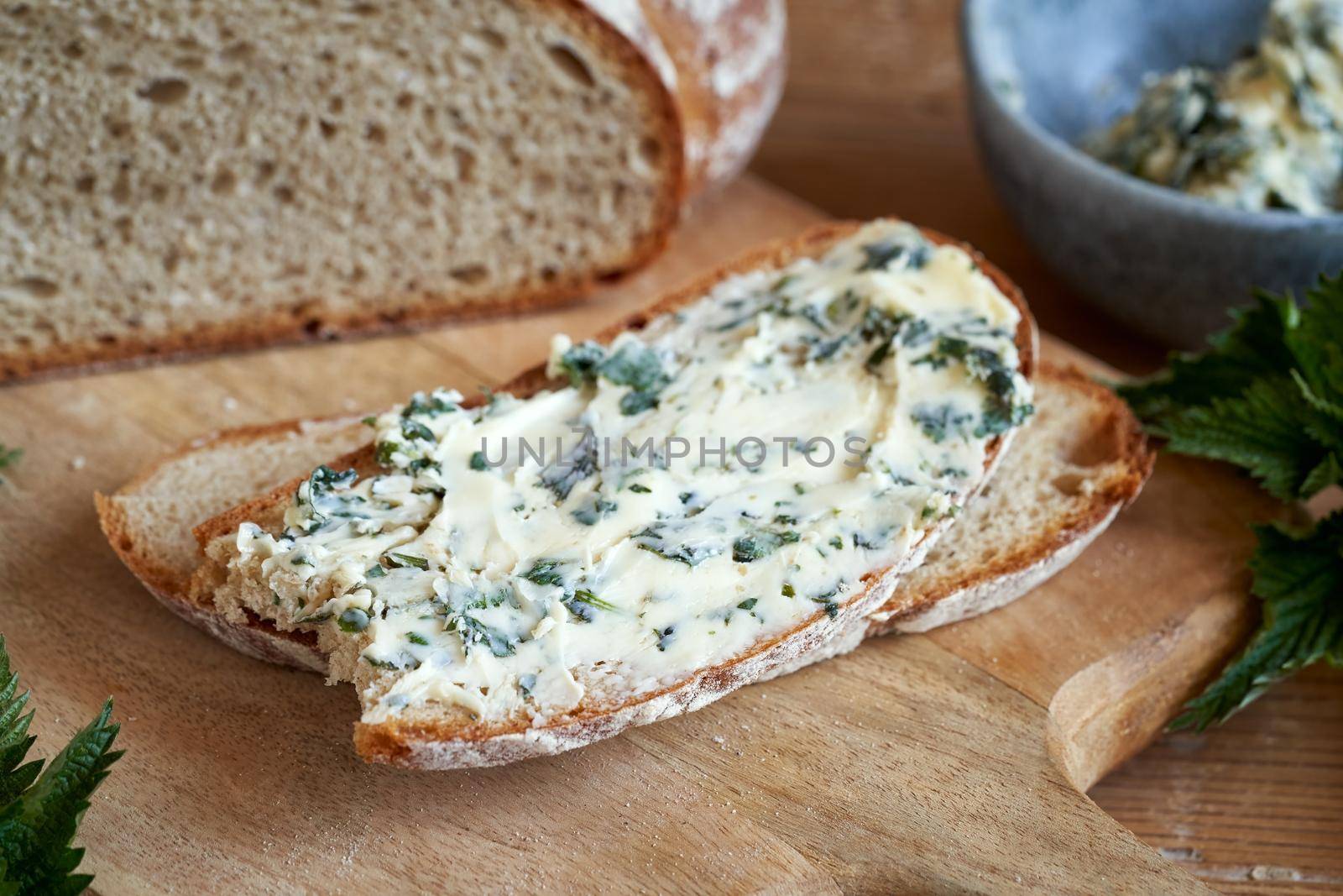 Slice of bread with a herbal spread made from butter and fresh young nettles collected in spring