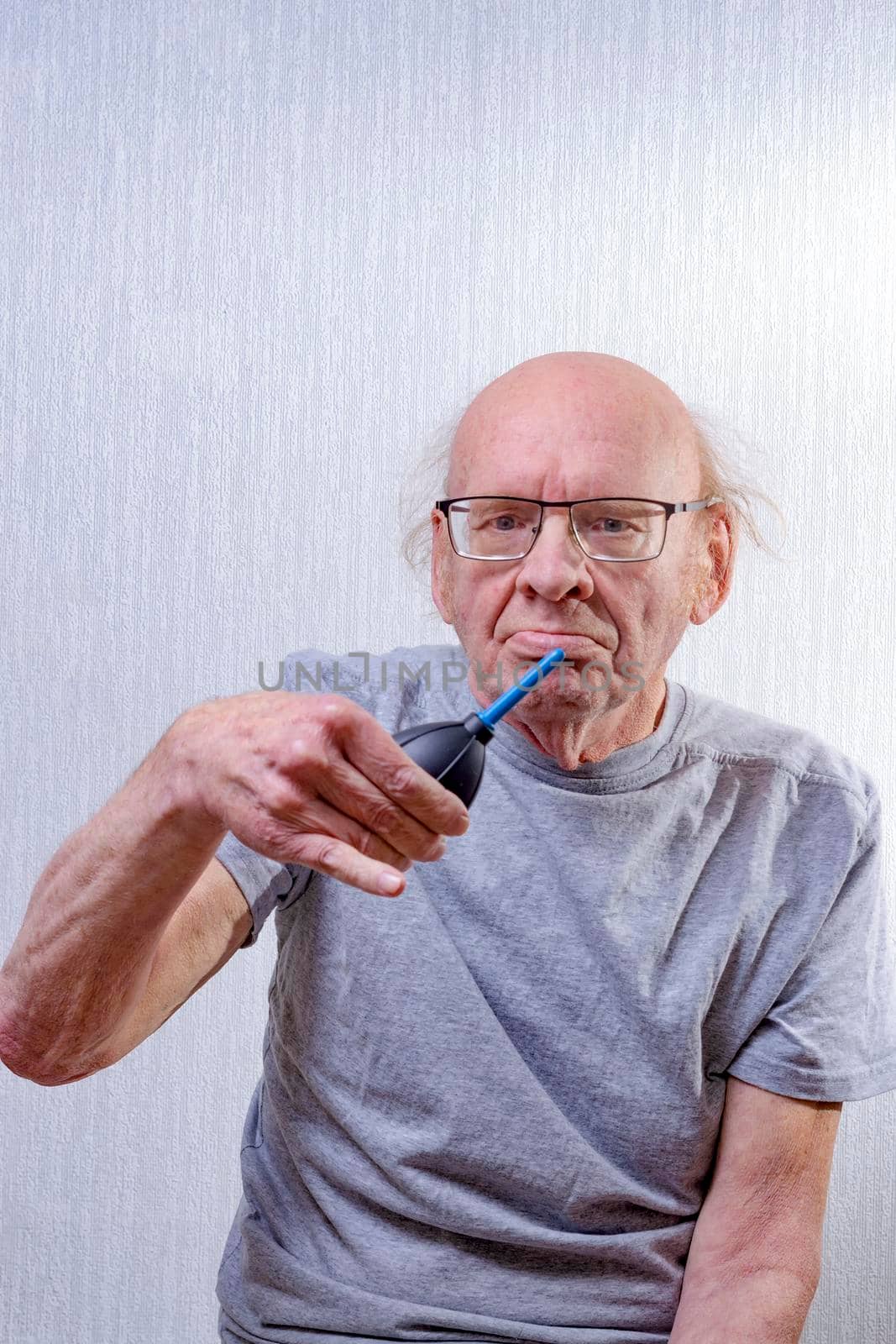 Elderly man holds pear in his hand to clean camera matrix. by Essffes