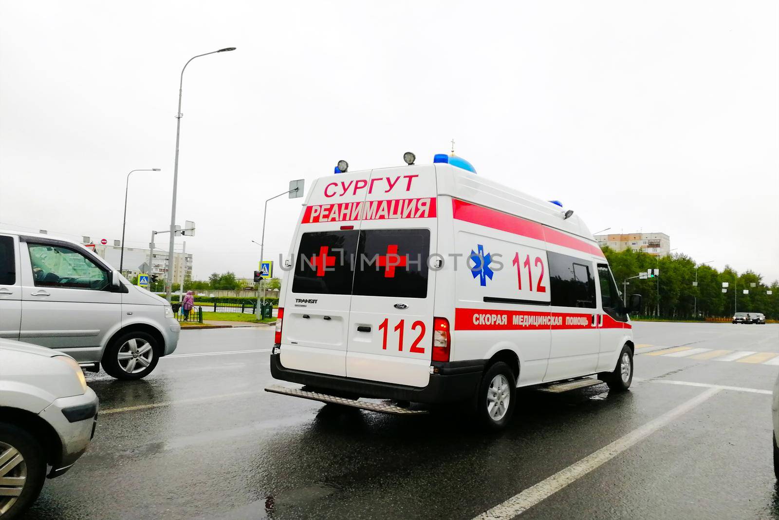 An ambulance blazes by, it's sirens whaling. An intentional camera blur gives a feeling of a rushed tension to the scene.